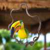 Colorful toucan figurine on a branch against a blurred natural background
