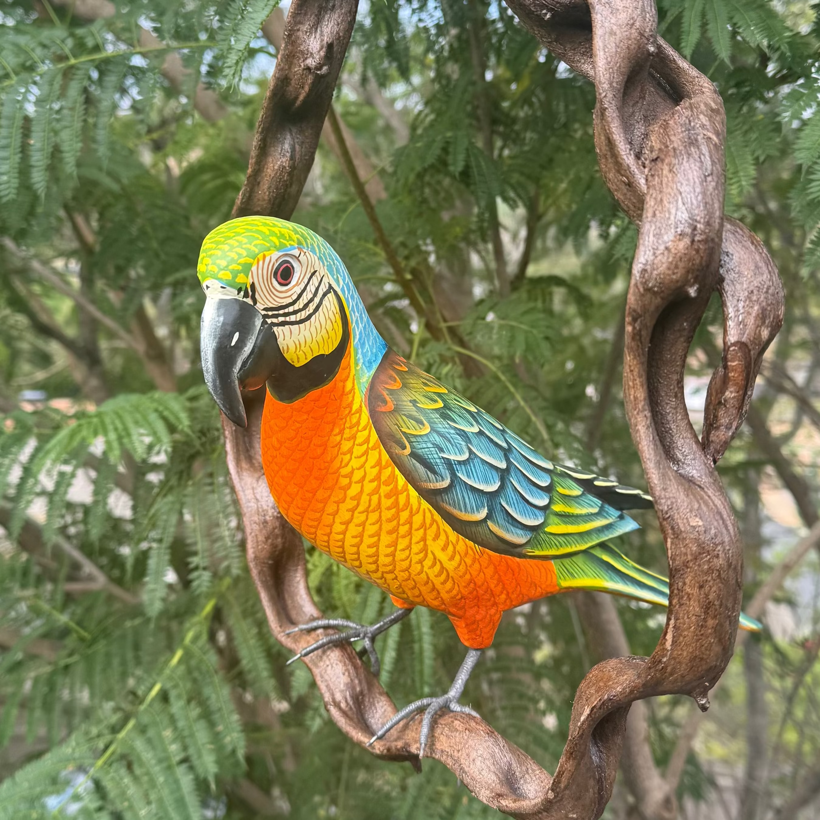 Colorful parrot perched on a branch with green foliage in the background