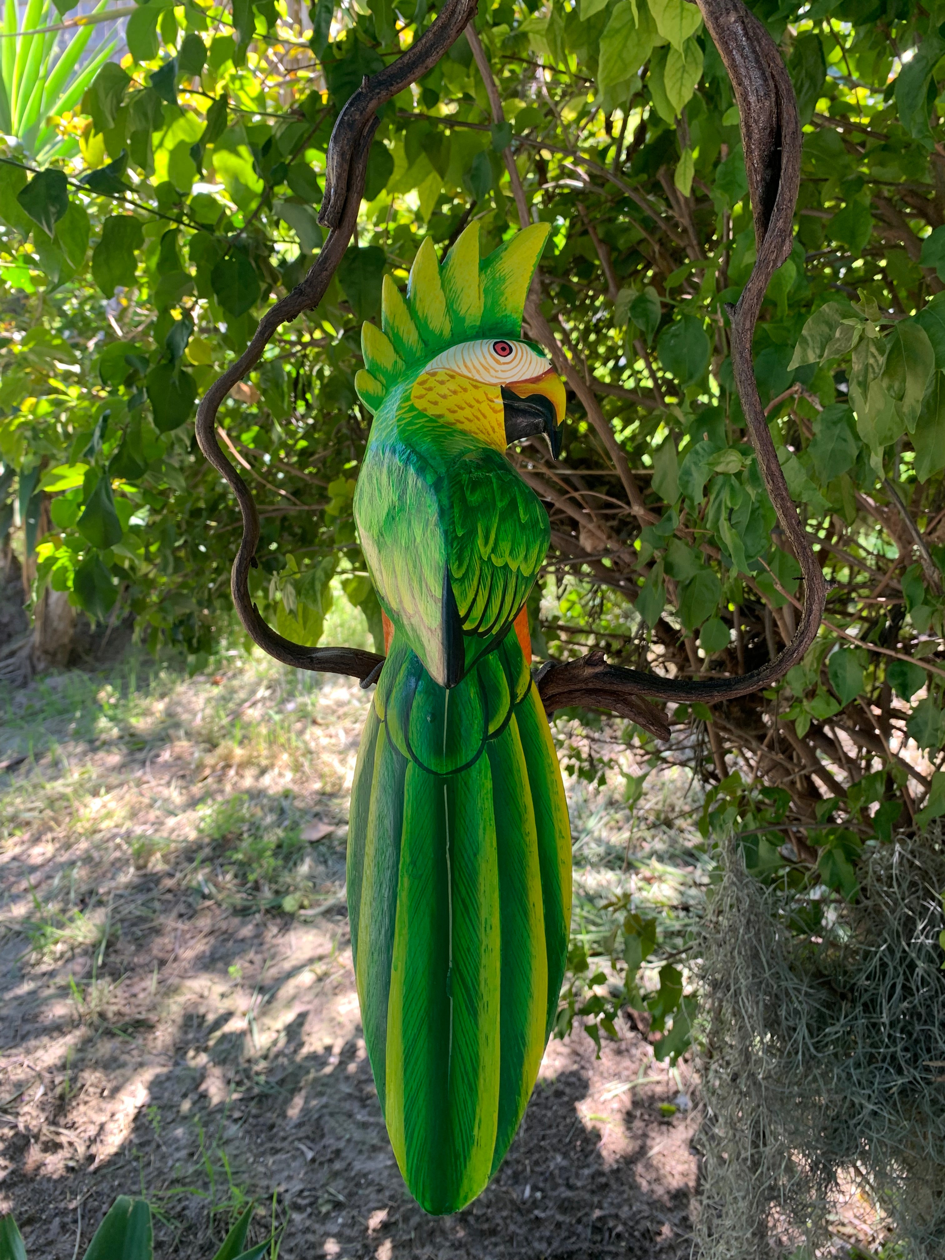 Decorative green parrot sculpture against a natural background