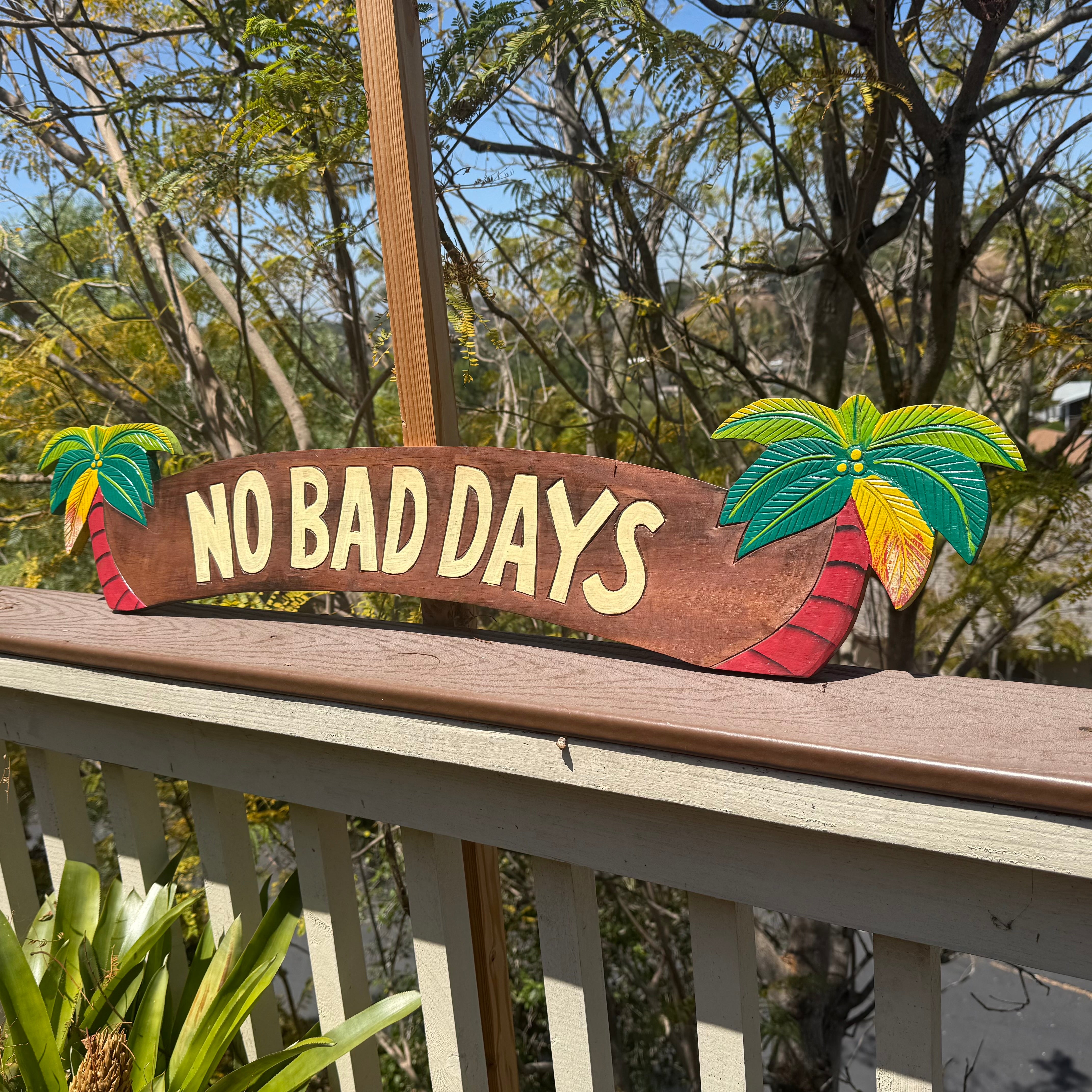 Decorative sign with 'No Bad Days' on a wooden surface outdoors.