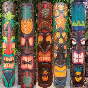 Set of colorful tiki masks with various designs against a natural background.