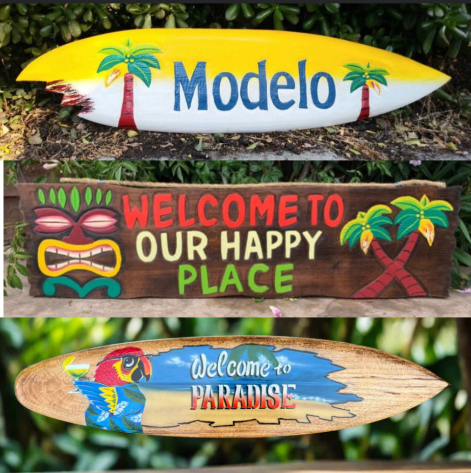 Three decorative signs featuring beer branding and tropical designs.