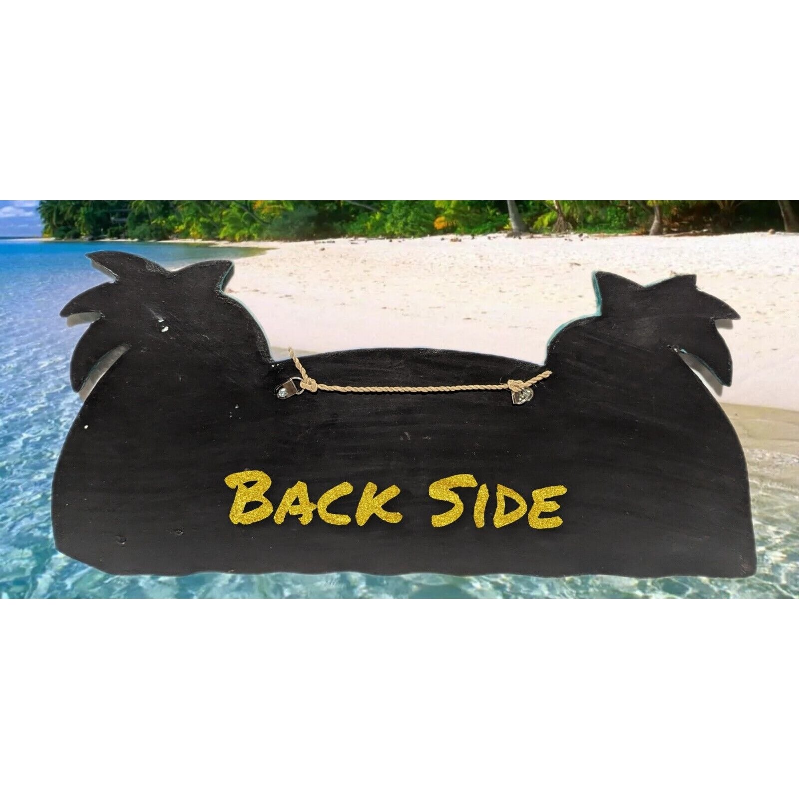 Black wooden rooster-shaped sign with gold 'BACK SIDE' text on a tropical beach background