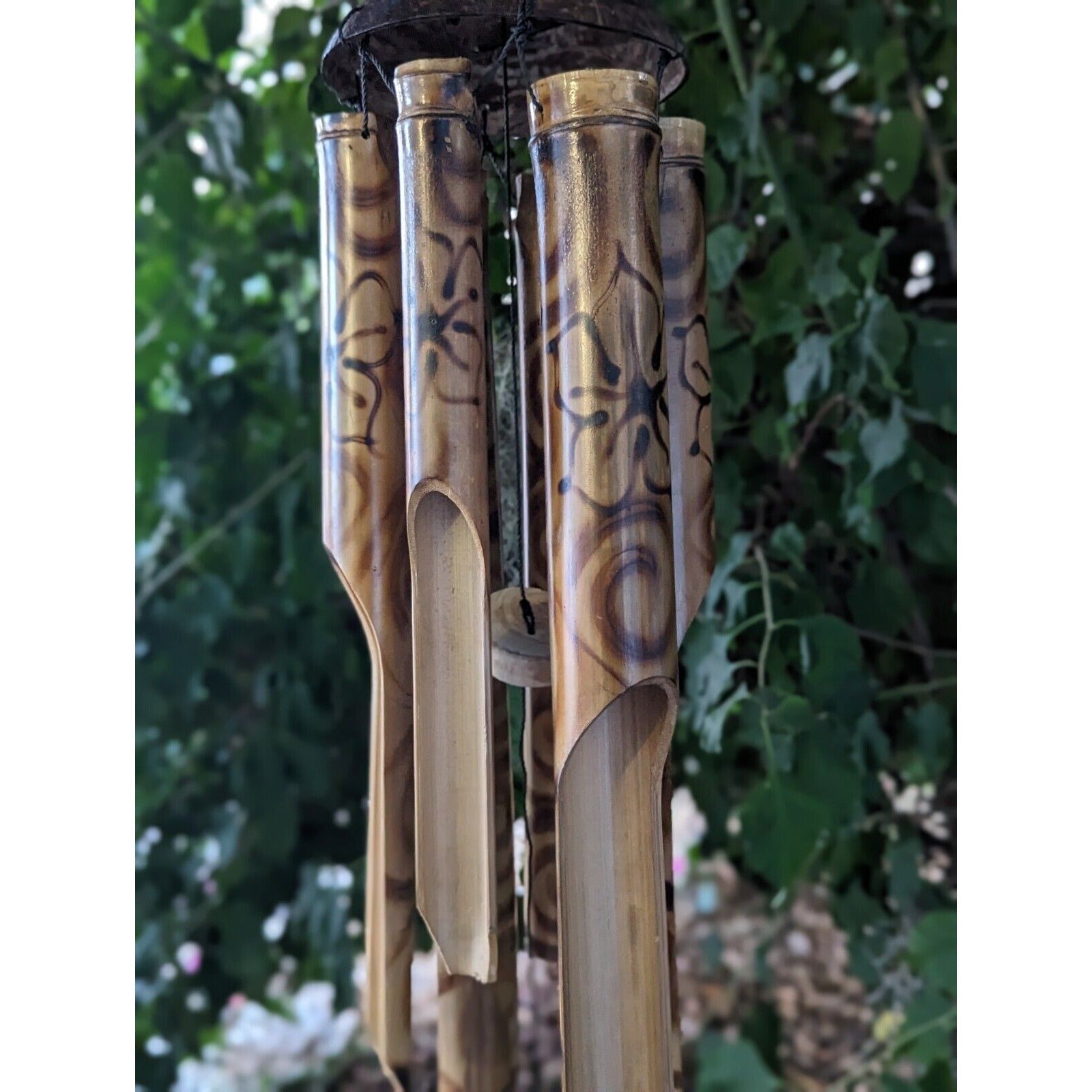 Bamboo wind chimes hanging outdoors in a garden