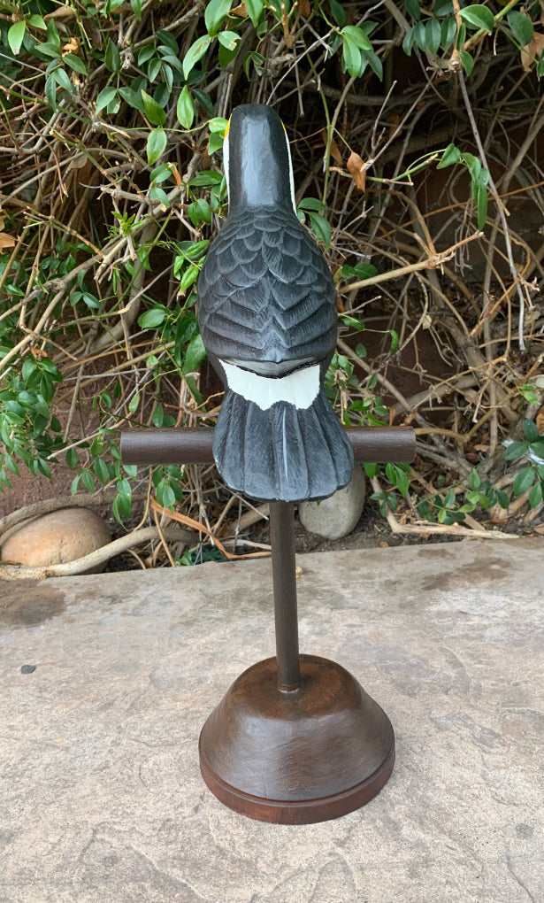 black crow statue on pedestal in garden