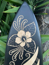 Black surfboard with beige hibiscus flower and Polynesian pattern