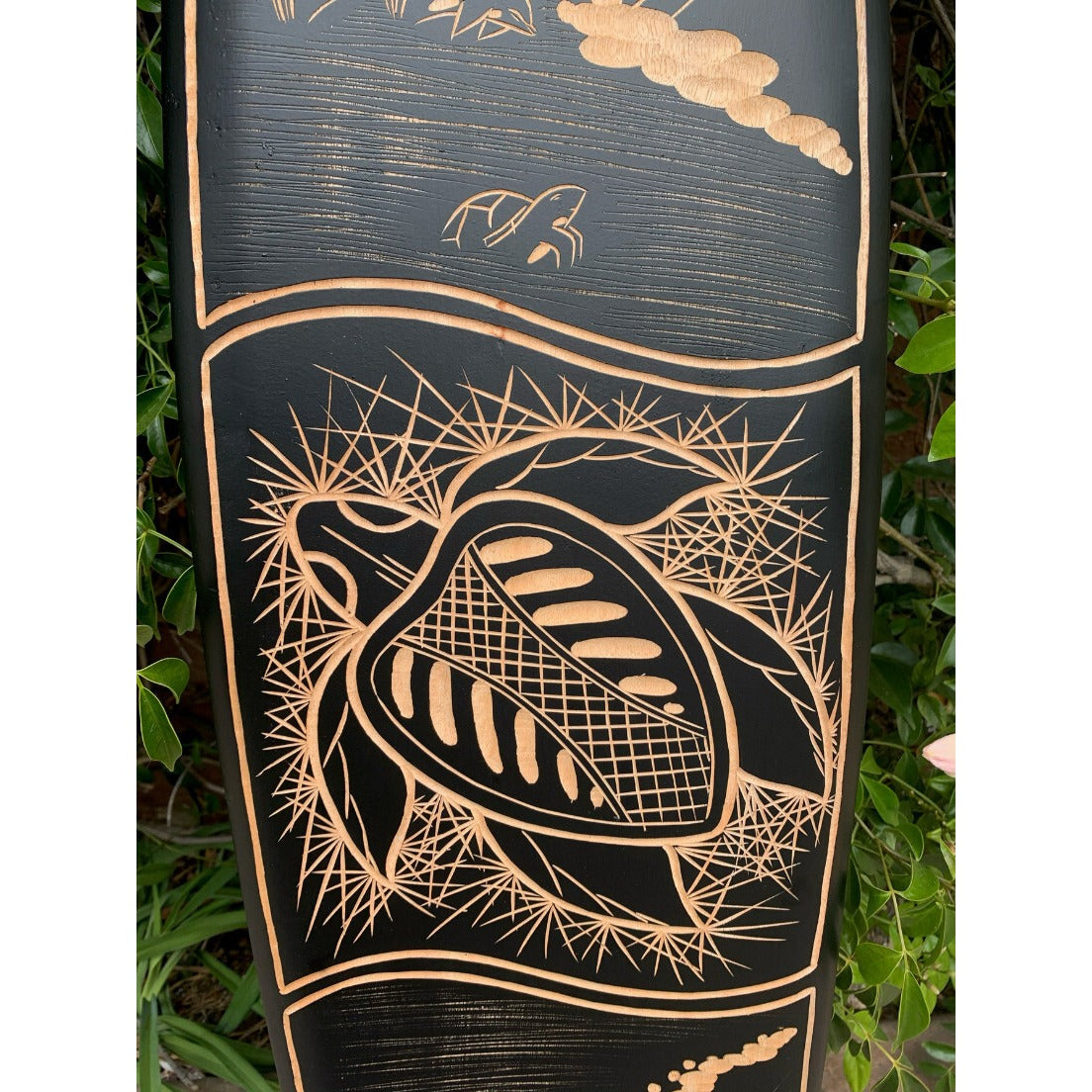 Copper-toned carved turtle and shell design on black wooden panel