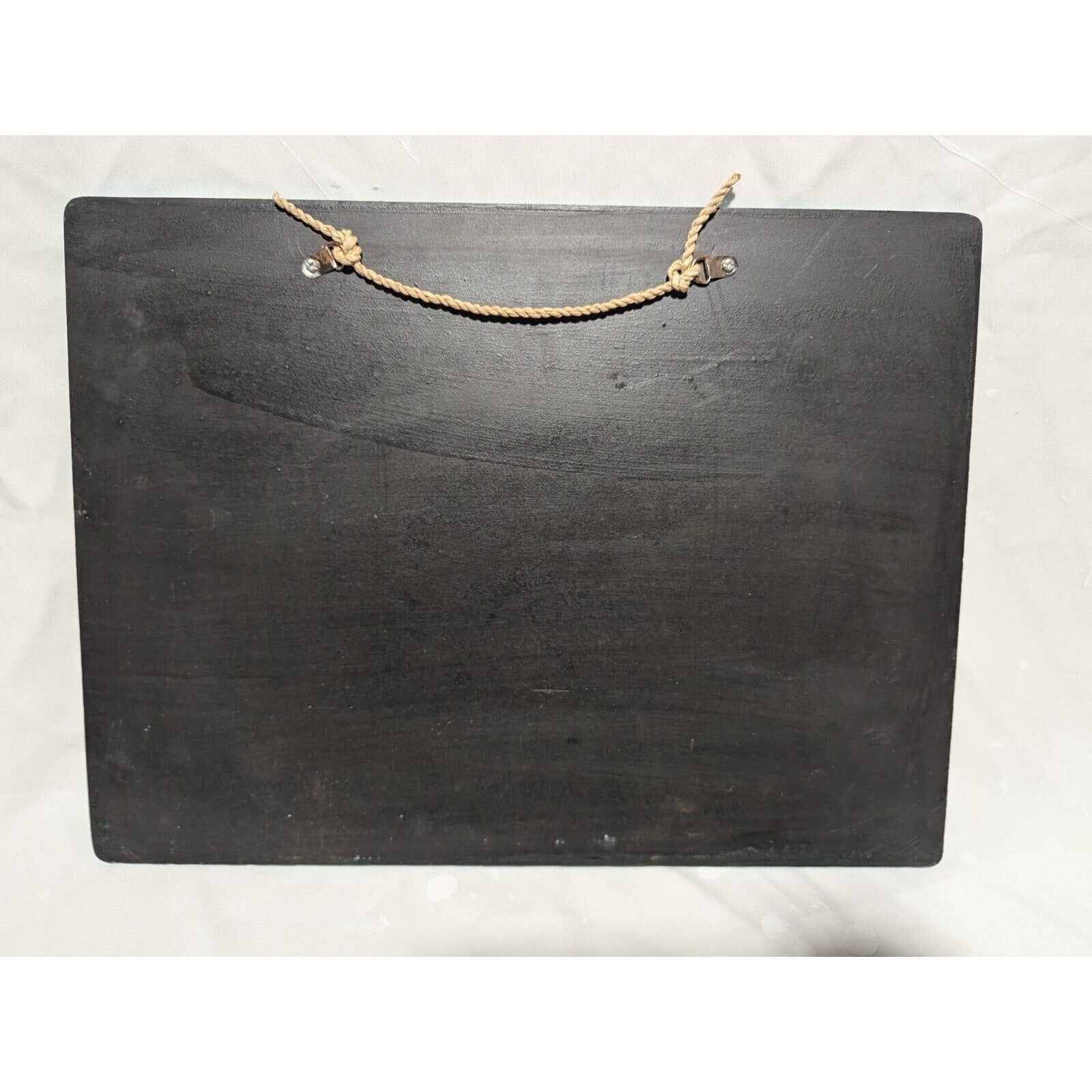 Black wooden signboard with a beige jute rope hanger