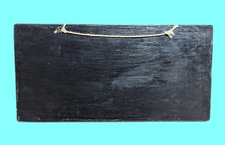 black wooden plaque with rope hanger on turquoise background
