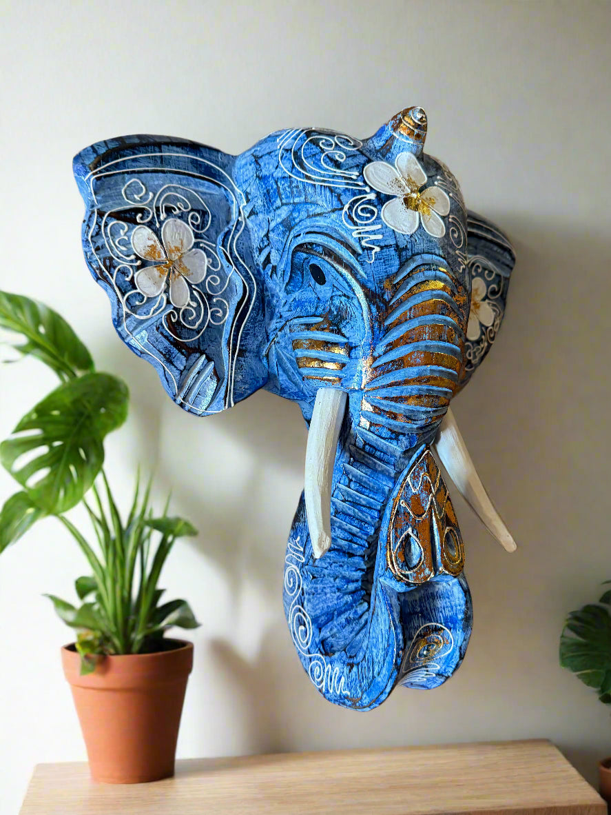 Blue elephant sculpture with white floral patterns and gold accents.