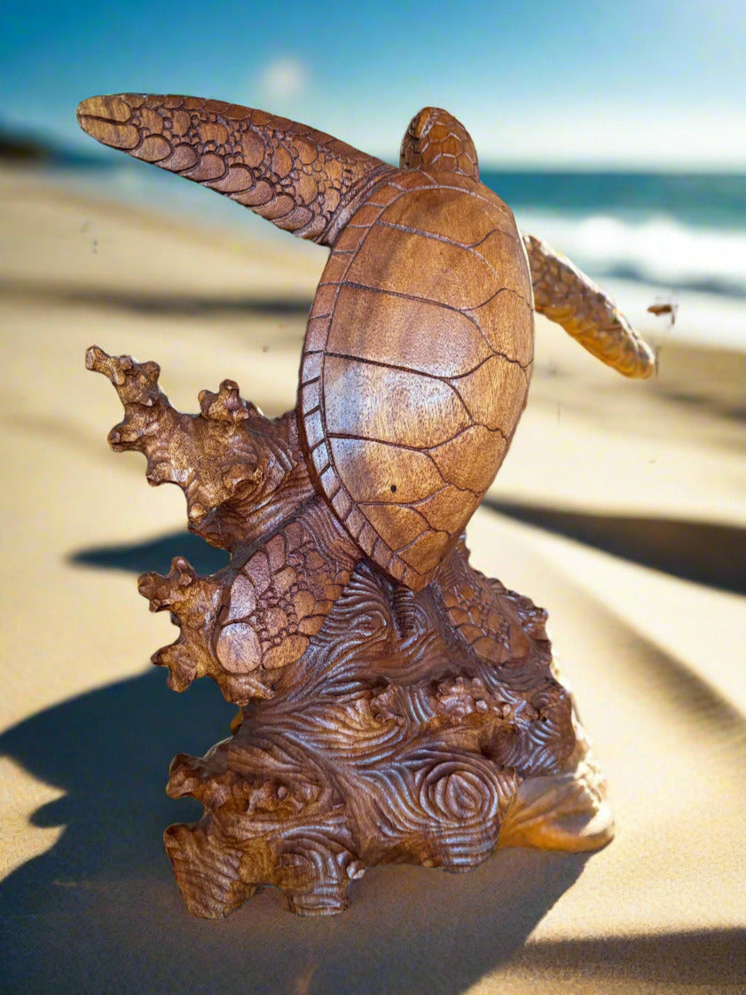 brown sea turtle statue on sandy beach with ocean in background