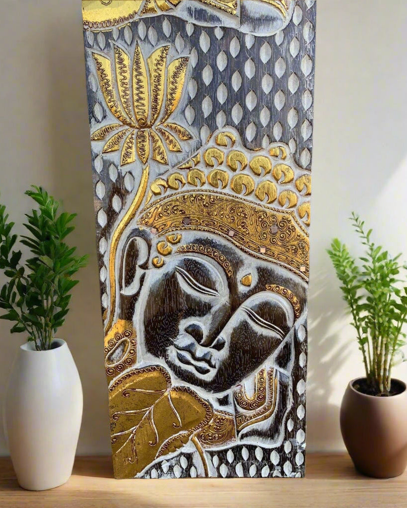 Ornate Buddha relief panel in gold and silver with a sleeping face and decorative motifs