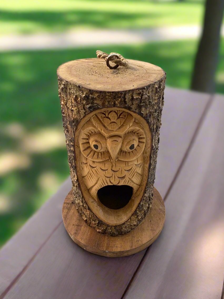 carved owl face on a tree stump with a rope loop on top