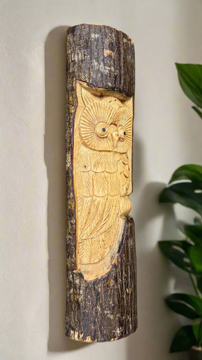 Carved wooden owl on a rustic log wall sculpture