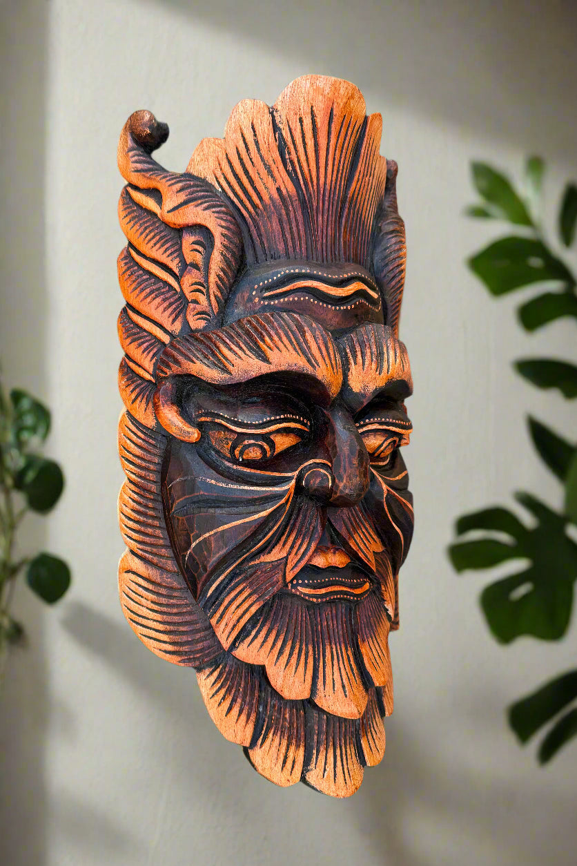 Carved wooden tiki mask with orange and dark brown details