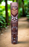 Carved wooden totem pole along forest path