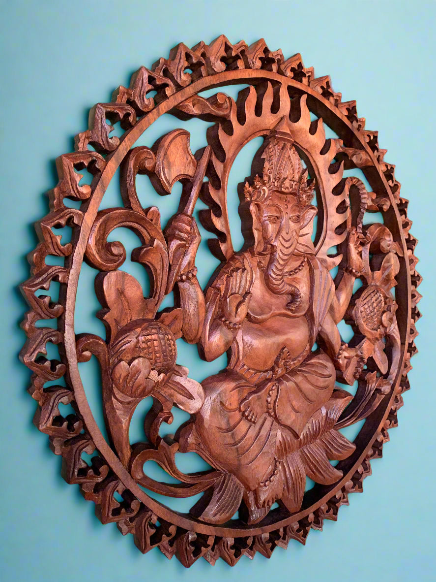 Intricately carved circular wooden wall plaque featuring Lord Ganesha among decorative foliage.