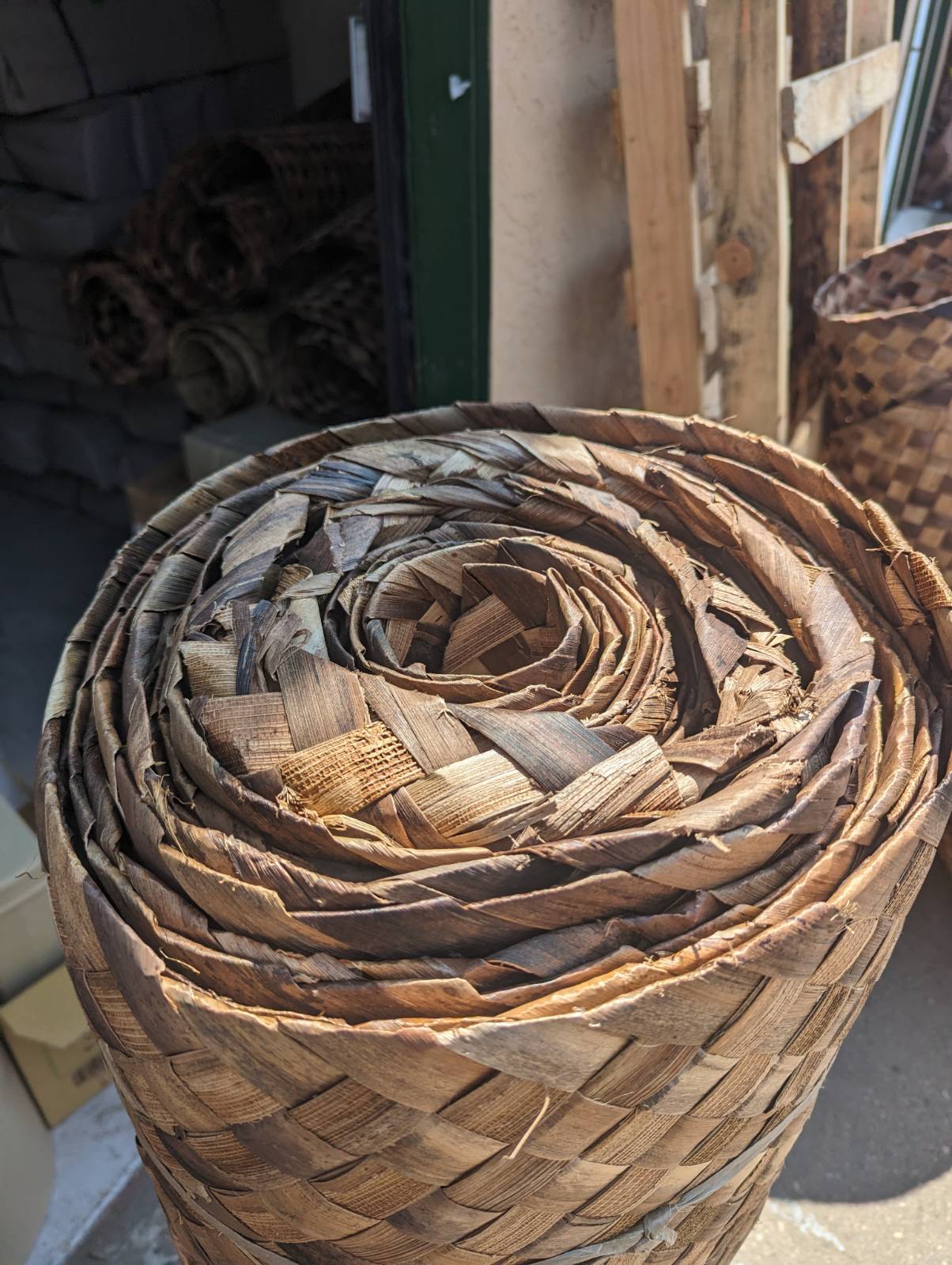 Close-up of a spiral, rolled woven basket made from dried palm leaves