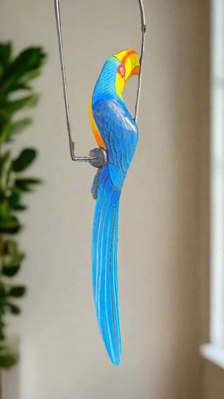 Colorful blue macaw parrot ornament perched on a metal wire.