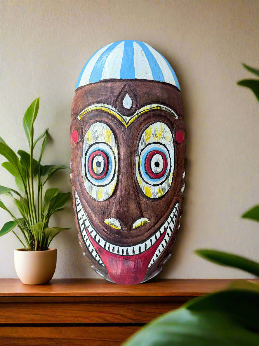 Colorful carved wooden tiki mask with blue-striped headdress and wide grin
