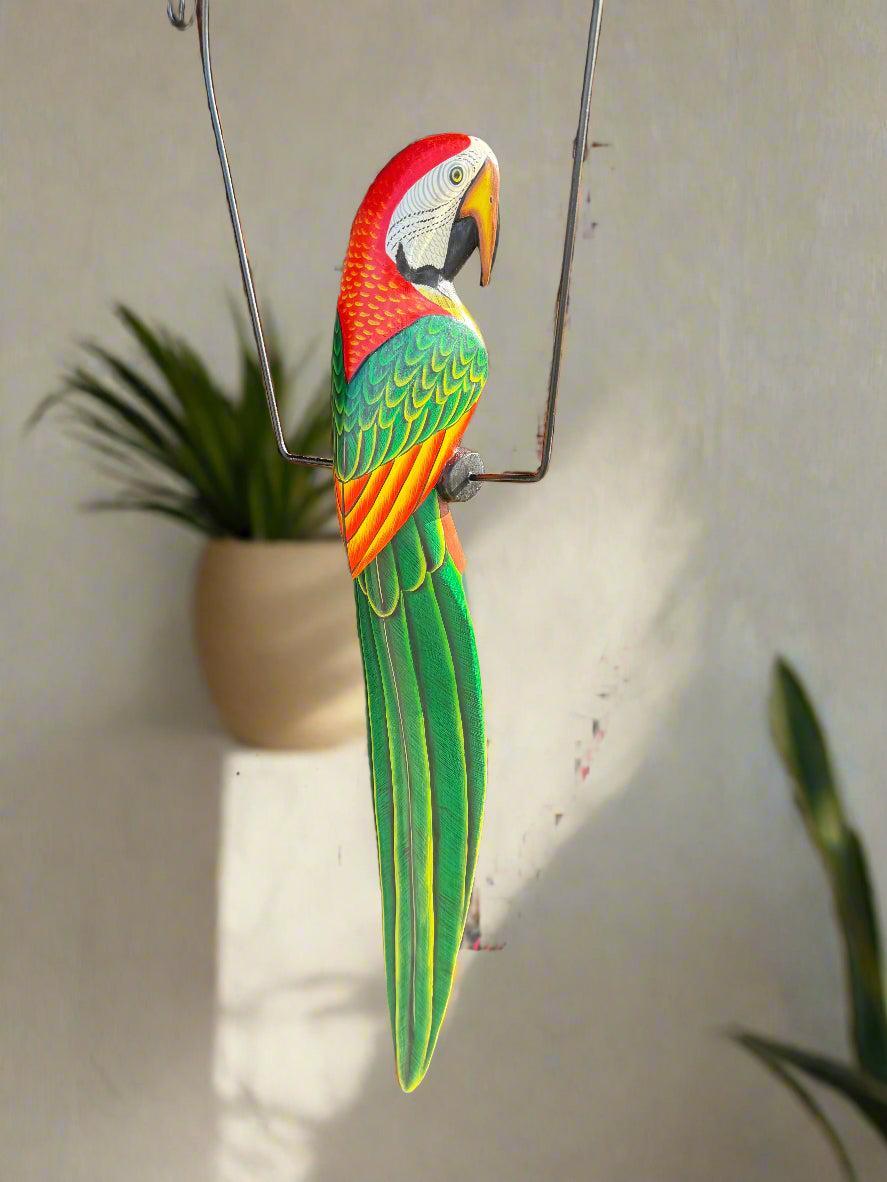 colorful macaw parrot sculpture hanging on a metal frame indoors