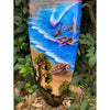 Painted ocean scene with dolphins and a sea turtle on a sandy shore