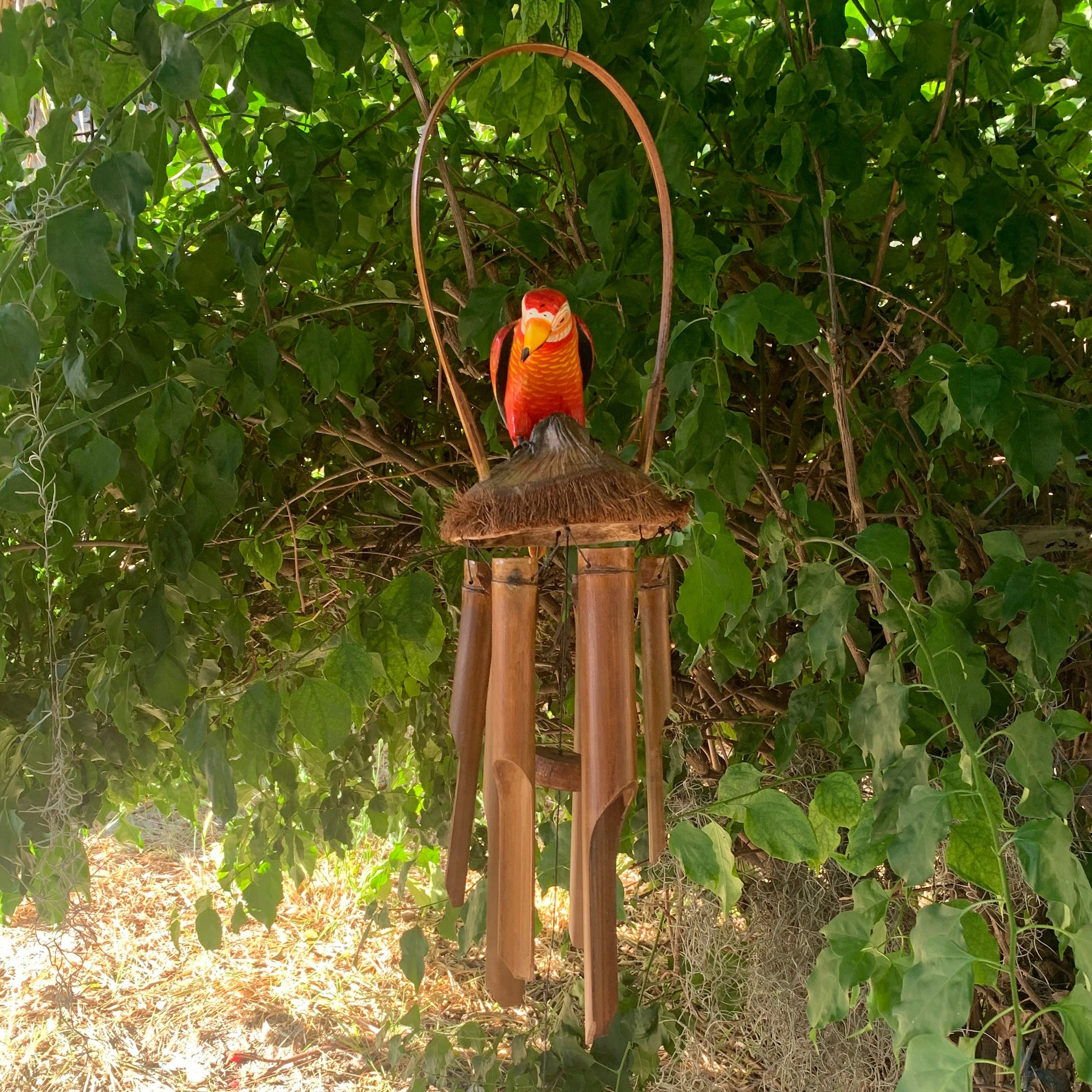 Colorful parrot wind chime with bamboo tubes hanging from vines