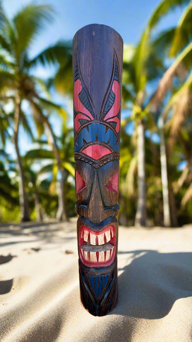 Colorful tiki carving on a wooden pole on a sunny beach with palm trees in the background