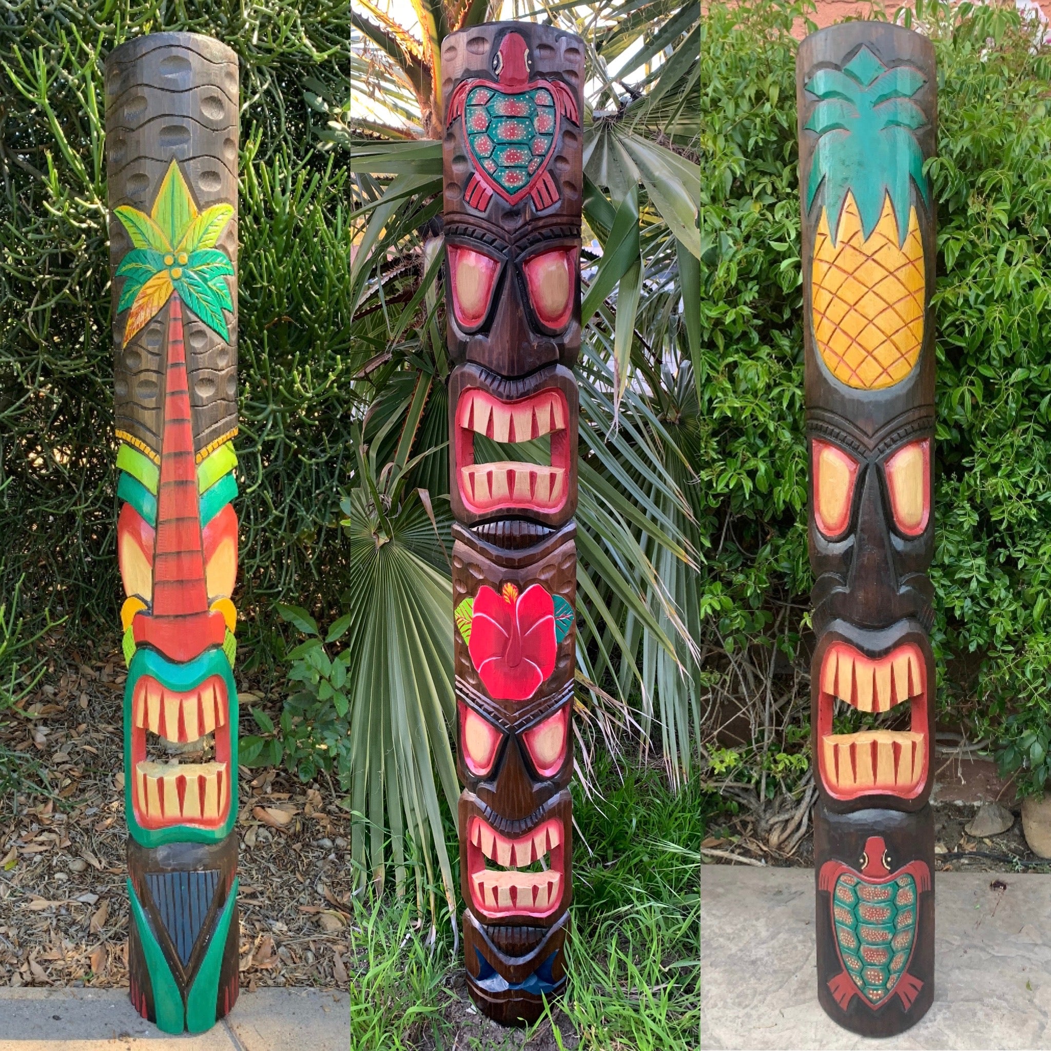 Three colorful carved tiki totem poles in a lush garden with tropical plants