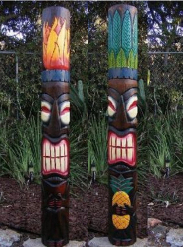 Two colorful carved totem poles with expressive faces in a garden setting