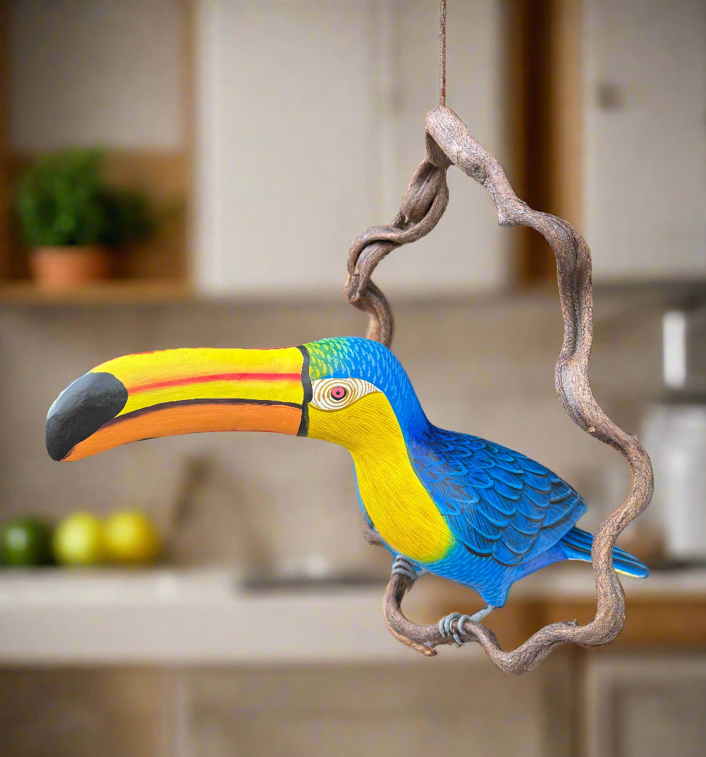 Colorful toucan perched on a twisted wooden branch indoors