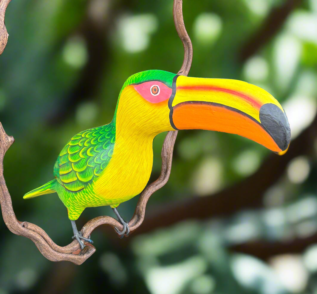 Colorful toucan perched on a branch with a bright yellow beak and green plumage