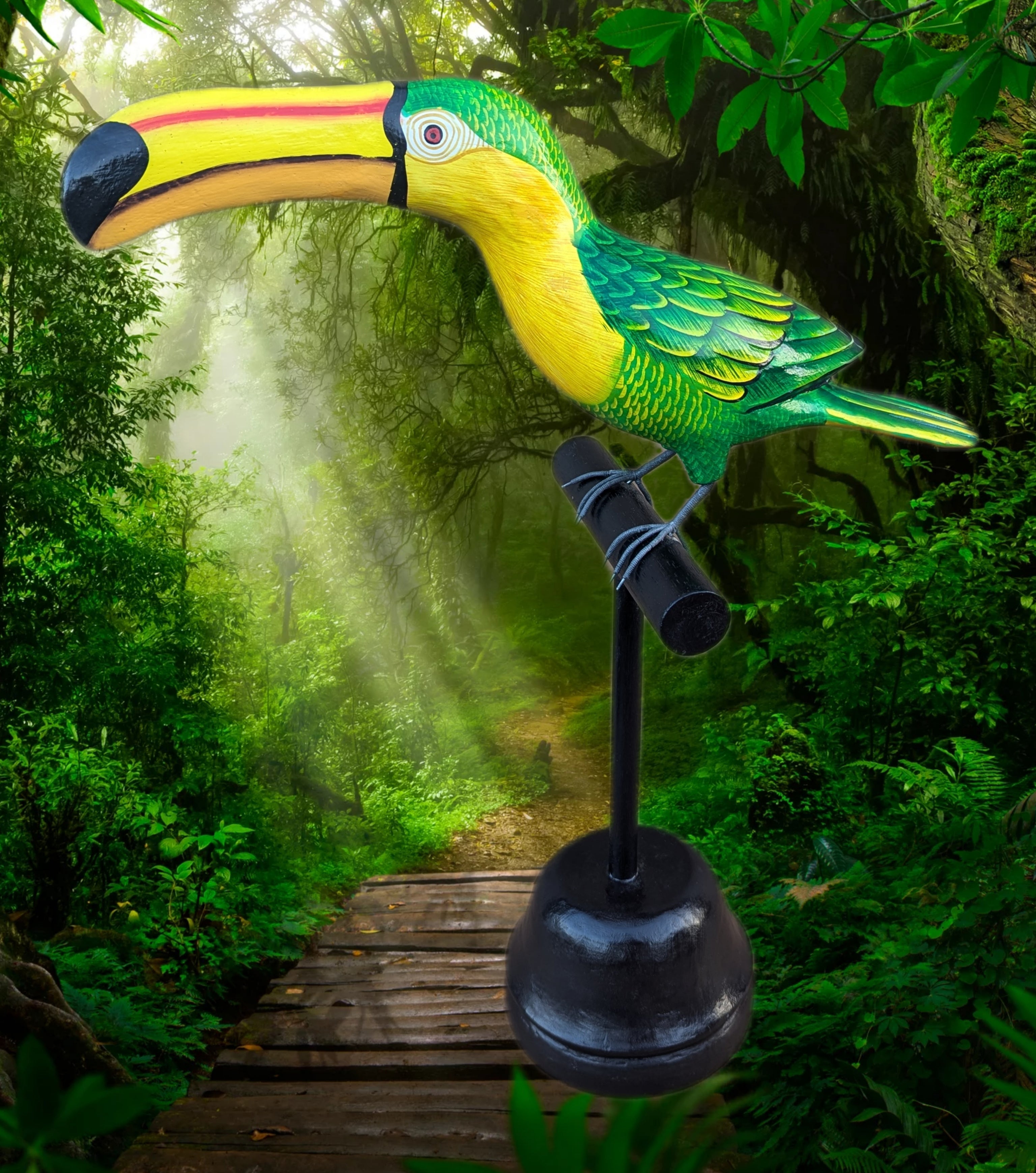 Bright green and yellow toucan sculpture on a stand in a lush forest path