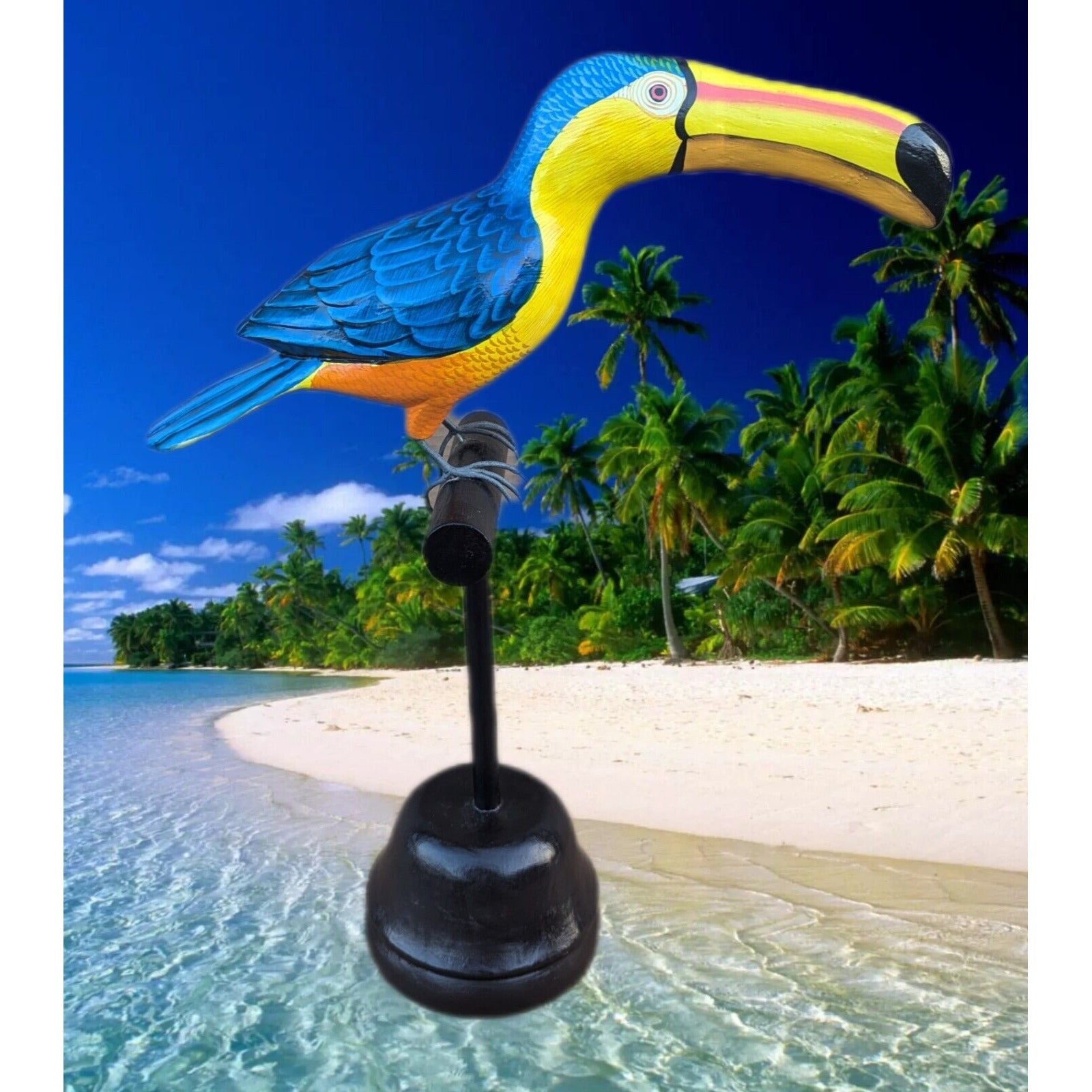 Colorful toucan sculpture perched on a stand at a tropical beach with palm trees