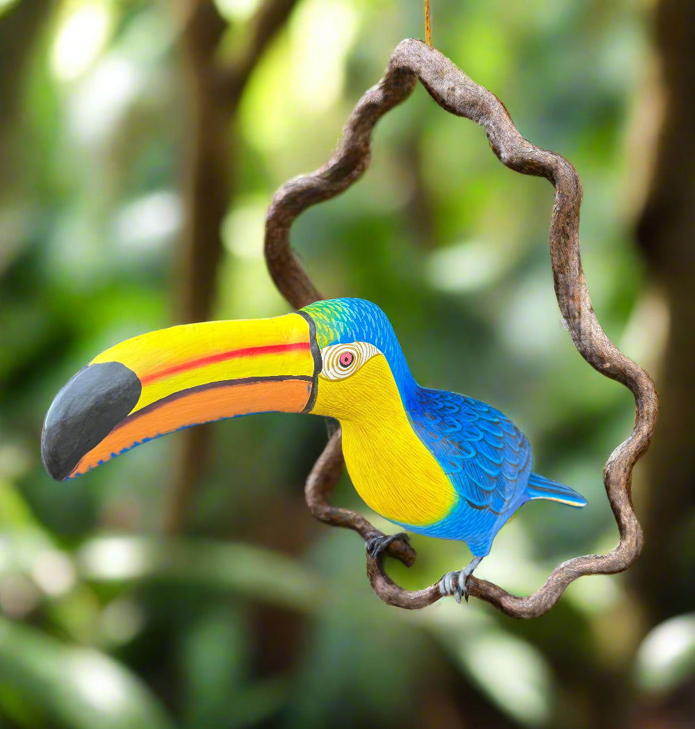 Colorful wooden toucan sculpture perched on a twisting branch in a garden