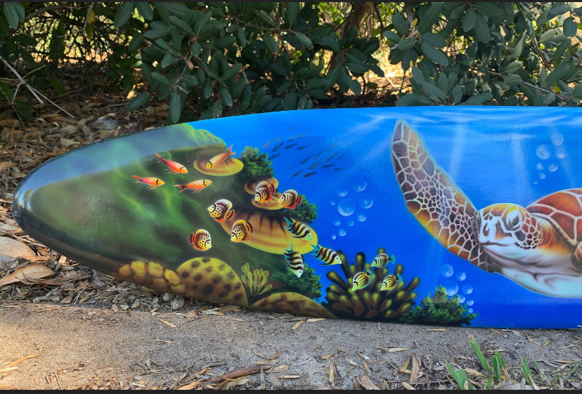 Colorful surfboard art with turtle, fish, and coral underwater.