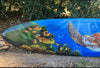 Colorful surfboard art with turtle, fish, and coral underwater.
