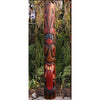 Colorful wooden totem pole carving with tribal patterns in a garden