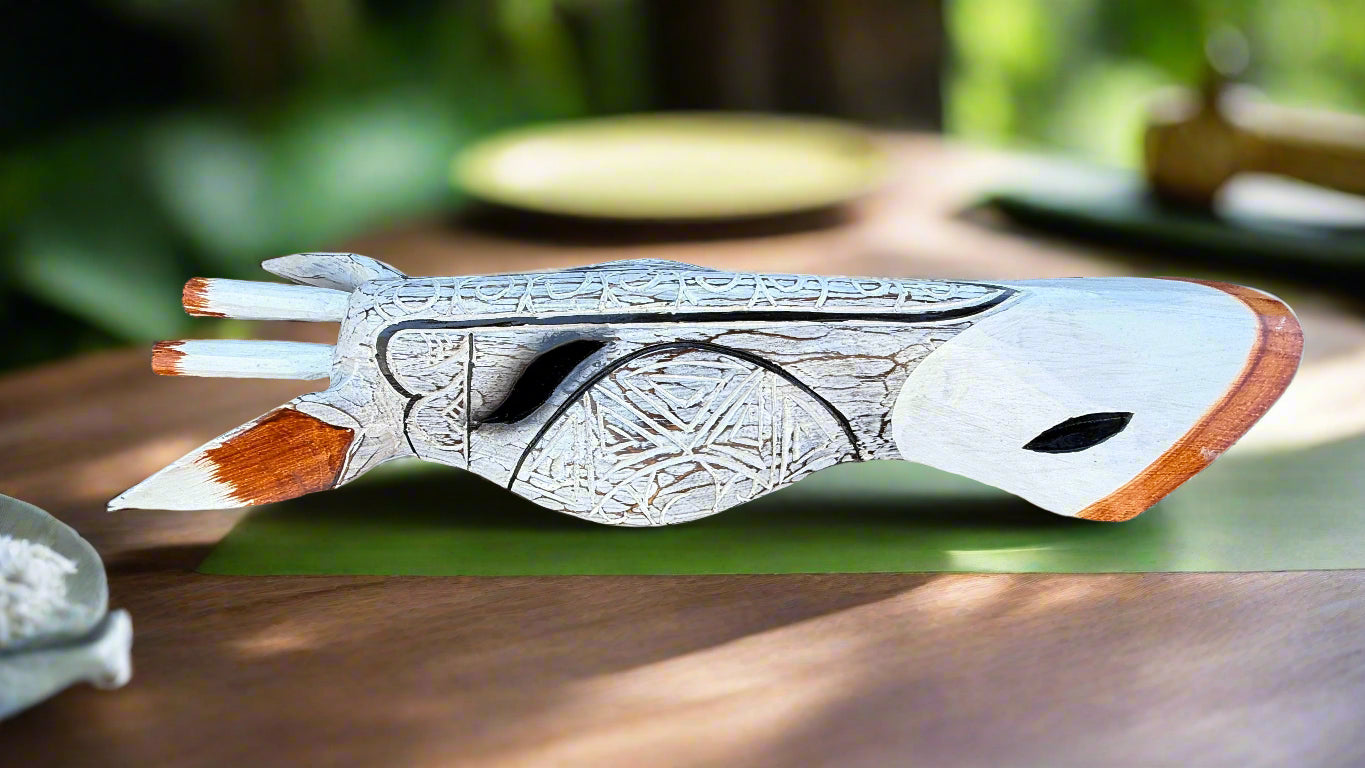 Decorative carved wooden pistol sculpture with intricate patterns