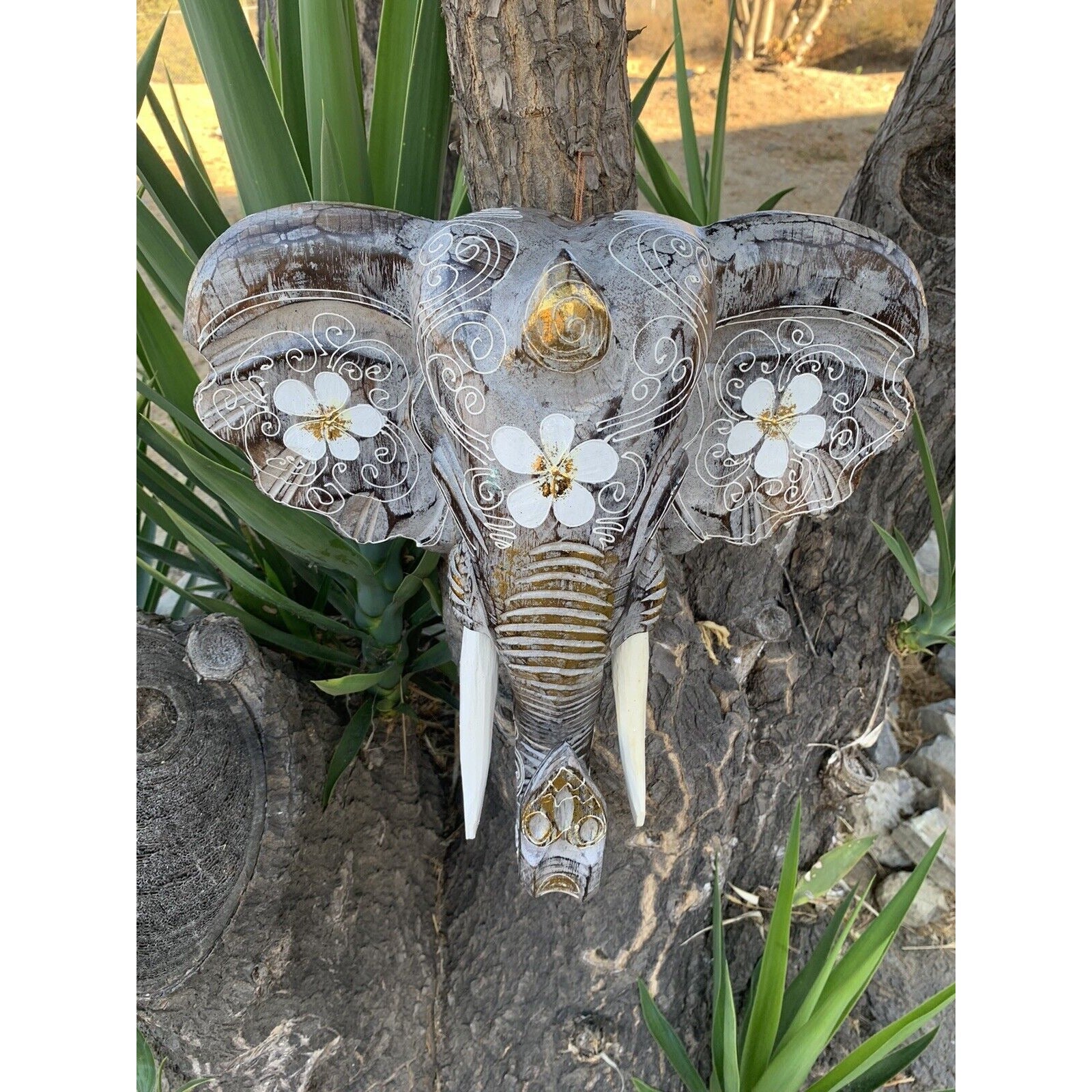 decorative elephant head sculpture with white floral patterns on ears