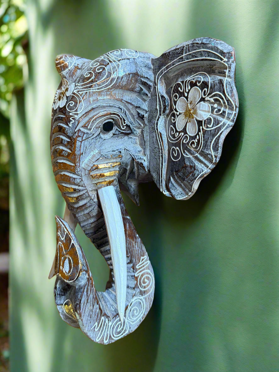 Decorative elephant head sculpture with white floral engravings