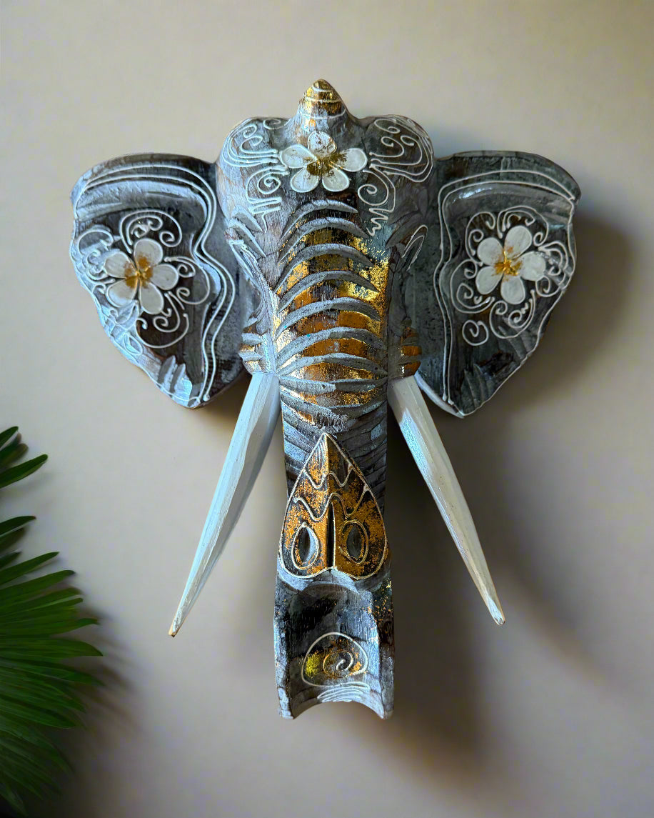 decorative elephant wall sculpture with white floral patterns and gold accents