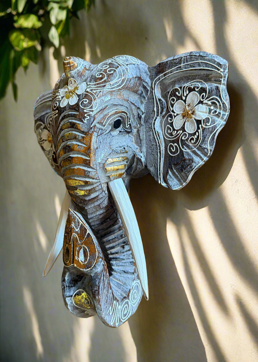 Decorative elephant wall sculpture with white floral carvings on a blue-gray finish