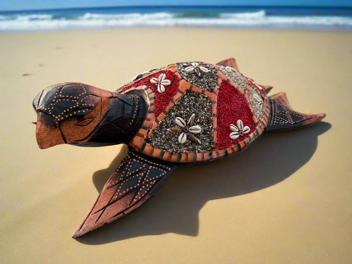 Handcrafted mosaic sea turtle sculpture on a sandy beach