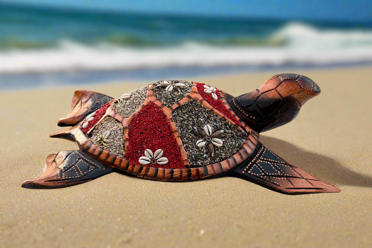 Decorative mosaic sea turtle sculpture on the beach with waves in the background