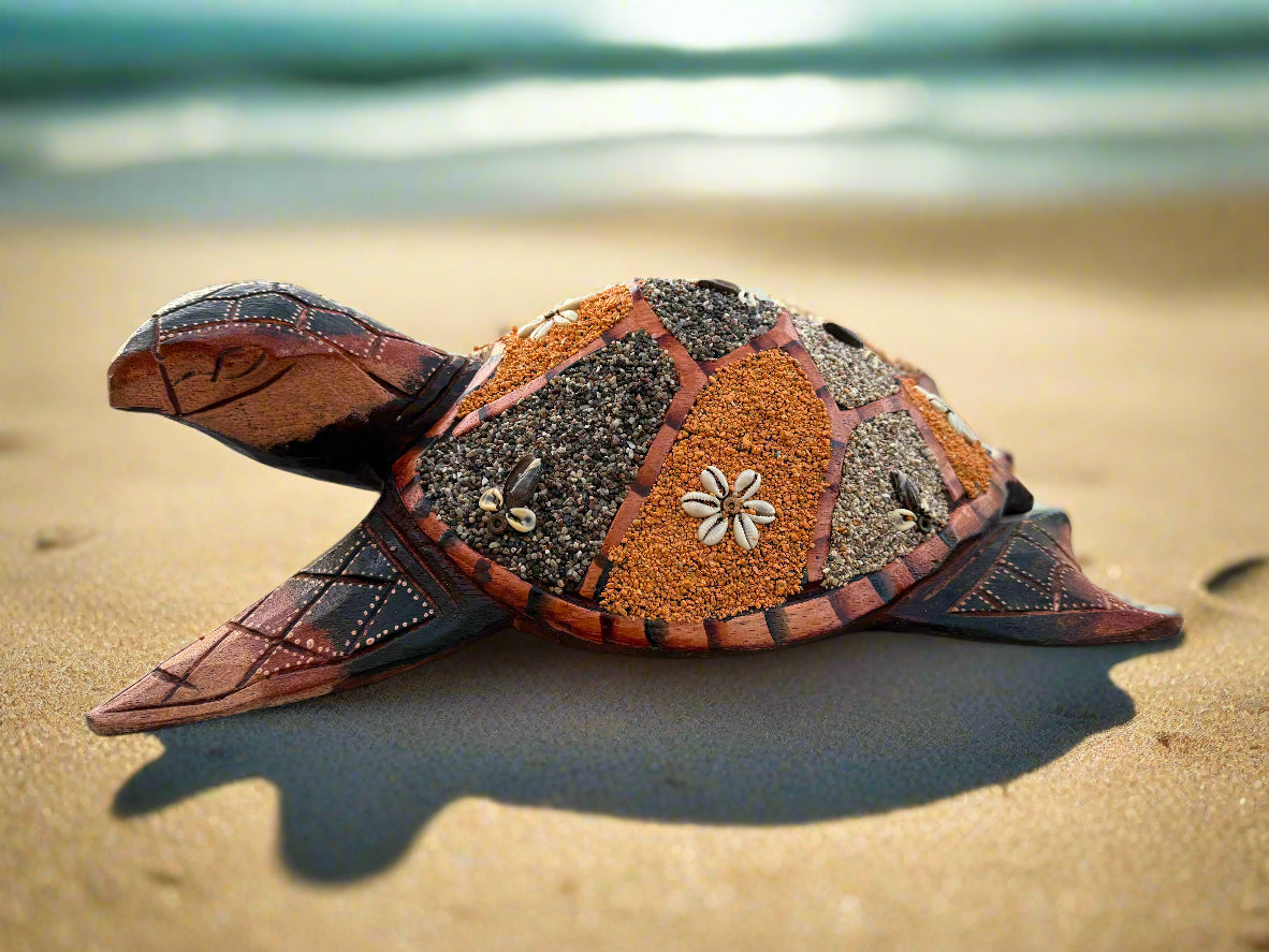 Decorative sand turtle sculpture with mosaic shell on the beach