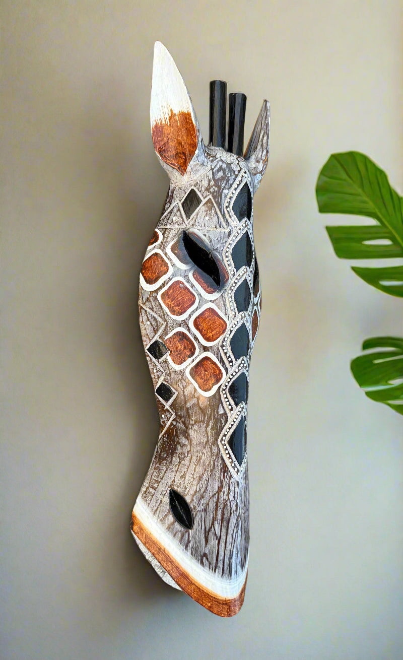 Geometric-patterned wooden animal head sculpture on wall with diamond shapes.