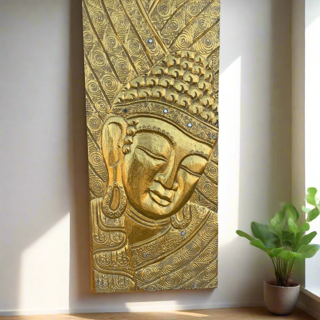 Gold Buddha head relief panel with ornate swirls and beaded crown on wall