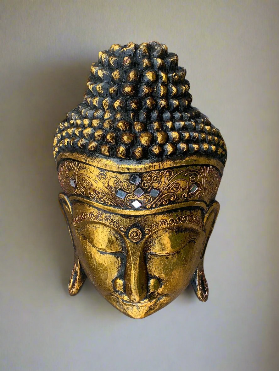 Golden Buddha head statue with ornate patterns and mosaic accents.
