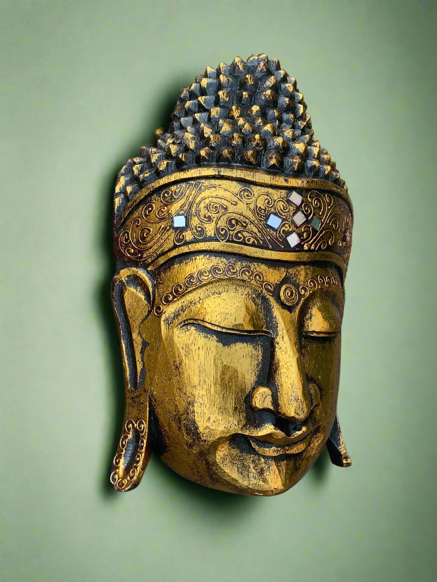 Golden Buddha head statue with ornate crown and decorative patterns on a green background